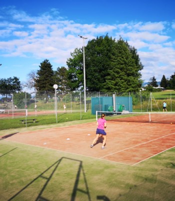 Joueurs de tennis en plein match sur un court de tennis extérieur, en plein soleil